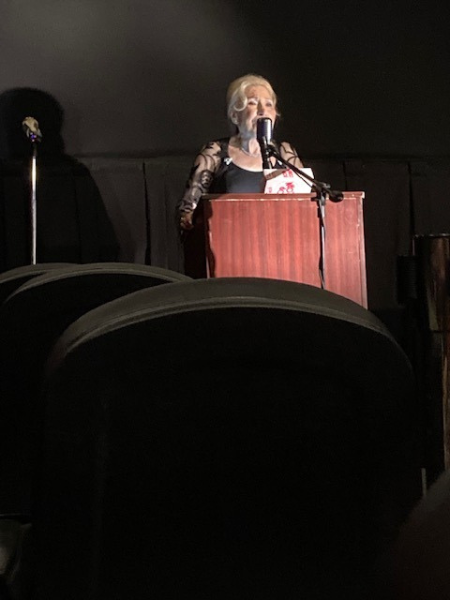 Premiere Chairman Elayne “Laynie” Flamm speaking at the Rainbow in the Night Movie Premiere, Life Story of Jane "Goldie" Winn, Delray Beach, Florida, June 4, 2023